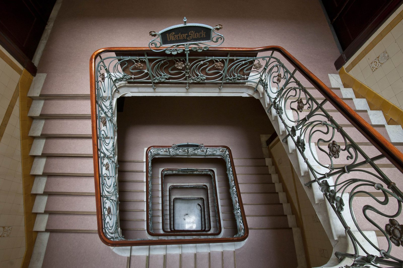Blick von oben in ein historisches Hamburger Treppenhaus mit geschwungenem Jugendstil-Geländer