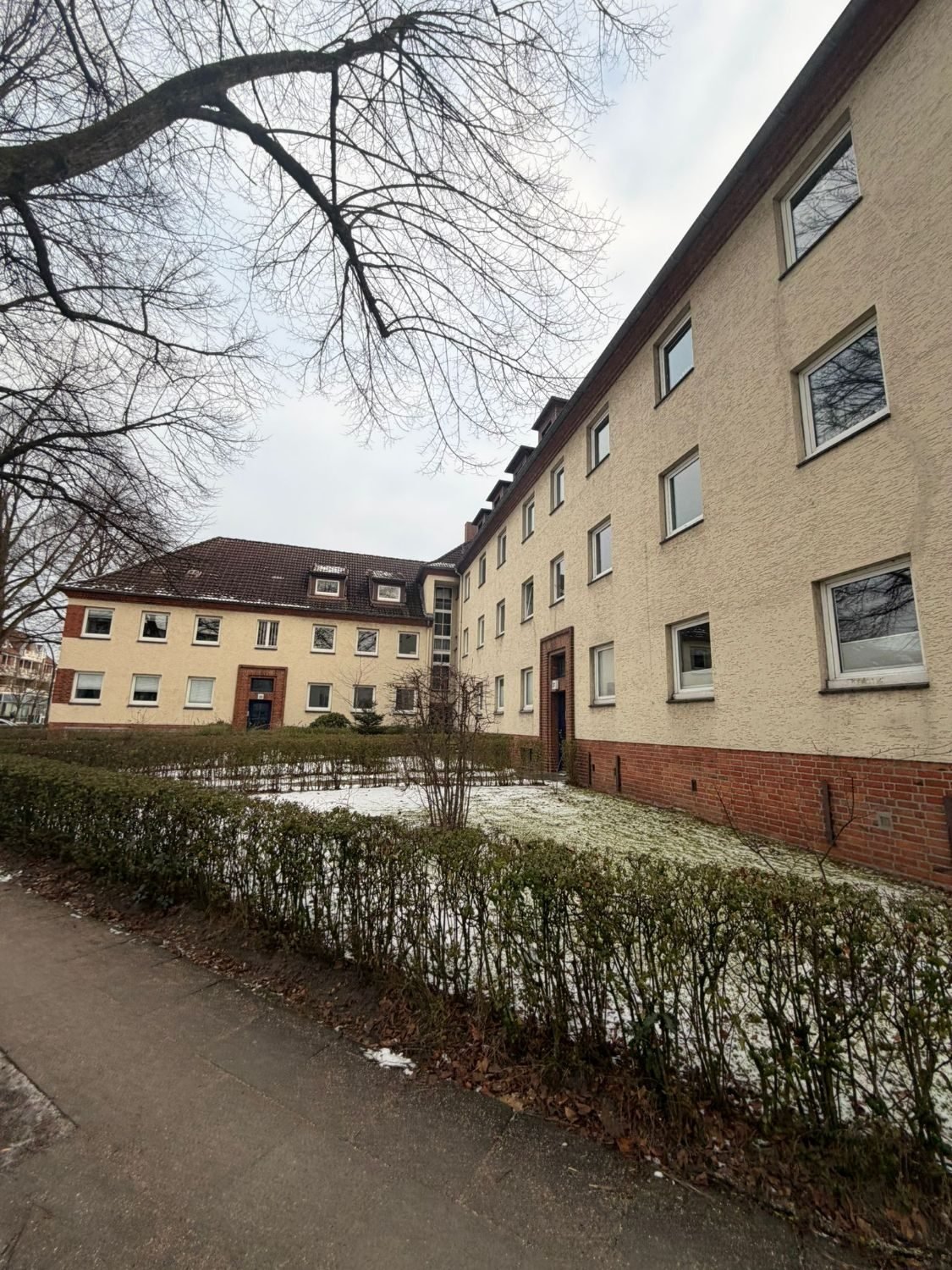 Wohnanlage mit Putzfassade und Klinkersockel
