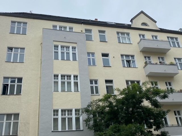 Altbau mit hell verputzter Fassade und Balkonen